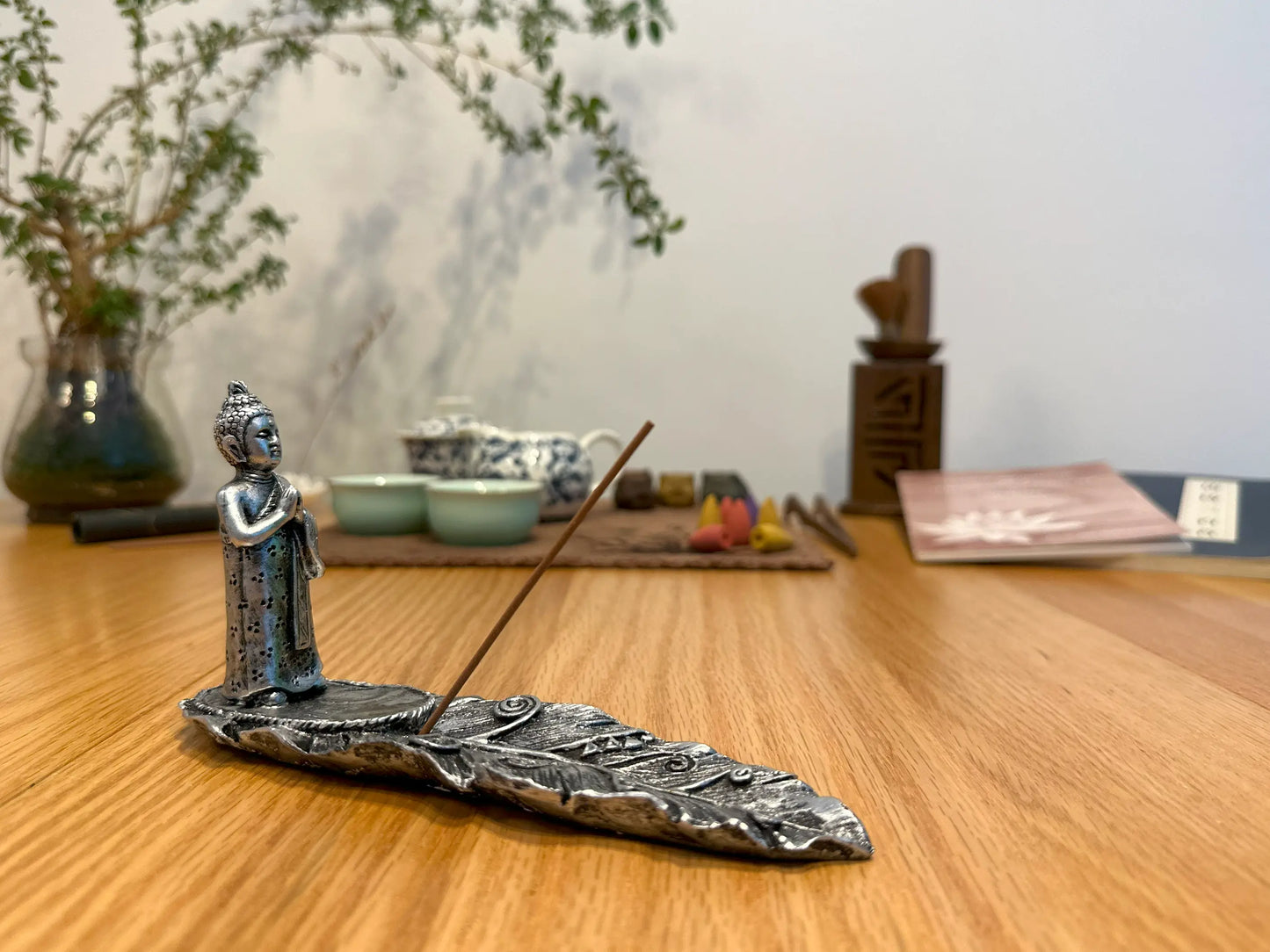 Räucherstäbchenhalter silberfarbener Buddha stehend auf einem Blatt und betet